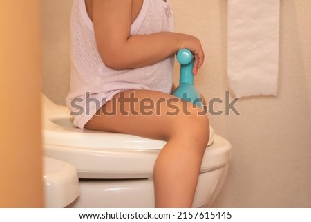 A toddler sitting on the toilet for toilet training or potty training