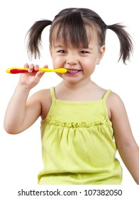 Toddler Smiling While Brushing Her Teeth Isolated On White