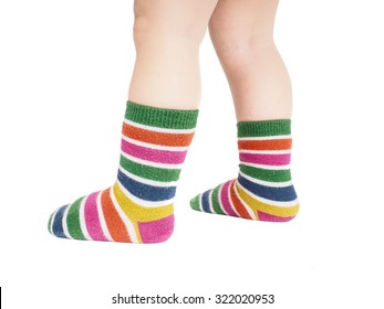 Toddler Standing In Striped Socks And Bare Legs Isolated On White