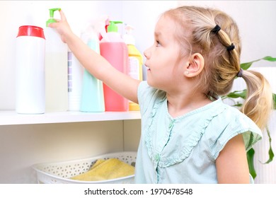 Toddler Touches Bottles Of Household Chemicals, Household Cleaning Products. Dangerous Situation