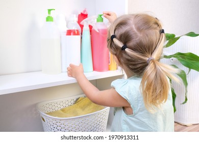 Toddler Touches Bottles Of Household Chemicals, Household Cleaning Products. Dangerous Situation