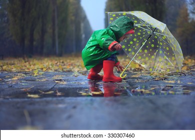 Toddler And Umbrella In Autumn Rainy Park