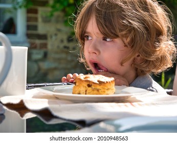 A Toddler Uses Self Control To Avoid Eating A Scone In Front Of Him