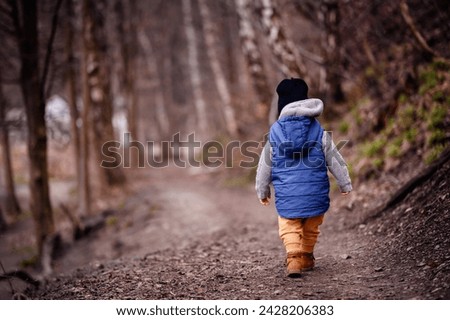 Toddler's Adventure: Exploring the Forest Path in Warm Winter Clothes