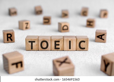 TOEIC - words from wooden blocks with letters, Test of English for International Communication TOEIC exam concept, white background