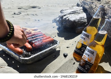 Tofino, British Columbia, Canada, 07-01-18: Closeup Of Small BBQ With Grilled Sausages On The Beaches Of Tofino With 2 Corona Bottles Next To It