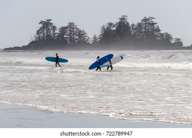Tofino, British Columbia, Canada - 9 September 2017: surfers holding surfboards on Chesterman Beach