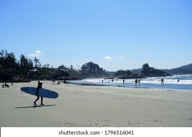 Tofino, Canada - August 6th, 2020: A view of people at Chesterman Beach with people swimming and surfing and enjoying the sun in Tofino, British Columbia, Canada.