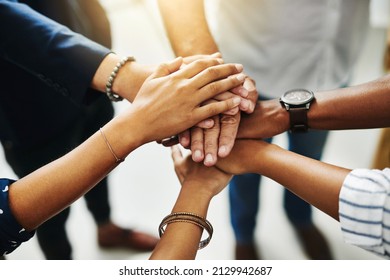 Together, anything is possible. Closeup shot of a group of unrecognizable businesspeople joining their hands together in a huddle. - Shutterstock ID 2129942687