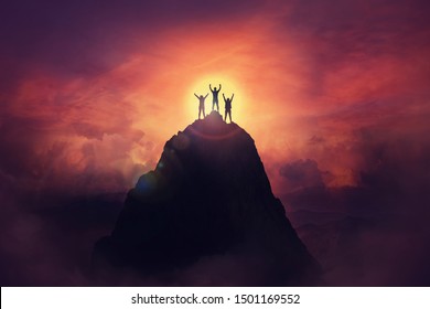 Together overcoming obstacles as a group of three people raising hands up on the top of a mountain. Celebrate victory and success over sunset background. Goal achievement symbol.