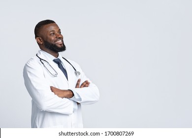 Together we can fight virus. Happy african american doctor in white uniform looking at copy space, white studio background