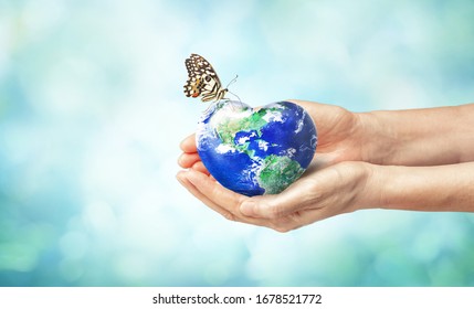 Together we can save the world and offer the better world for our children and Earth day concept, Butterfly and love heart shaped earth on hands, Elements of this image furnished by NASA