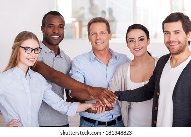 Together We Are Stronger! Group Of Cheerful Business People In Casual Wear Standing Close To Each Other And Holding Hands Together