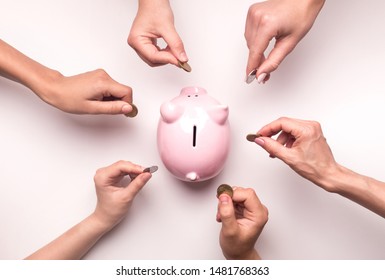 Togetherness concept. People hands throwing coins in piggy bank for crowdfunding, white background