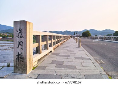 Togetsu bridge crossing the Katsuragawa early morning in Kyoto Arashiyama. On the left side of the photo is the Japanese kanji name of "Togetsu Bridge" engraved.