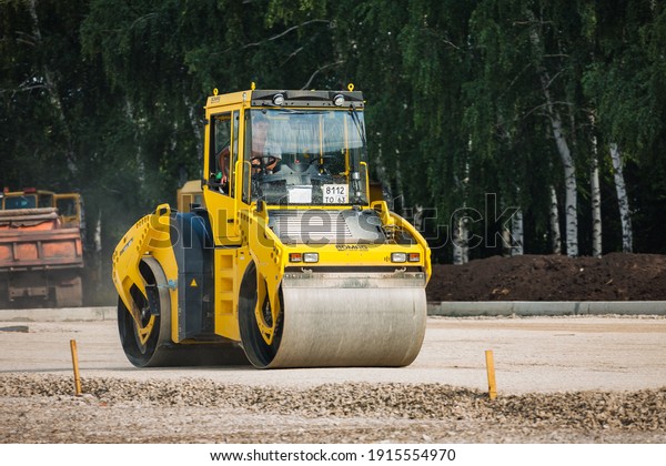TOGLIATTI,\
RUSSIA - JULY 21, 2008: Road cars work at laying of new asphalt.\
Special road machinery for asphalting construction works on a side\
of a road. Road construction and\
repairs