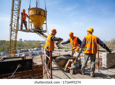 Togliatti, Samara Oblast / Russia - April 20, 2012: Concrete pouring on the construction of a hockey arena. Industrial workers accept concrete raised by a crane for pouring various building structures