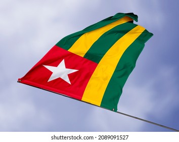 Togo's flag is isolated on a sky background. flag symbols of Togo. close up of a Togolese flag waving in the wind.