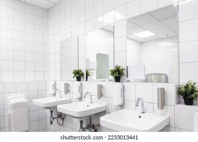 Toilet hand wash area with white colour ceramic tiles. White colour theme toilet interior. Cleanliness concept