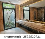 toilet interior design with many sinks by window and outdoor tree. A stylish washroom in a modern building.