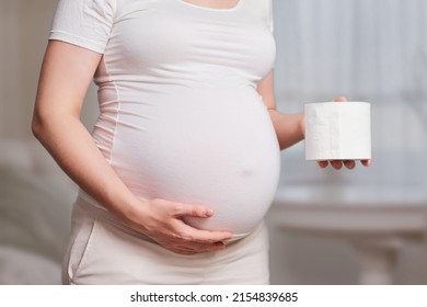 Toilet Paper In The Hands Of A Pregnant Woman, Studio Shot, Home Living Room