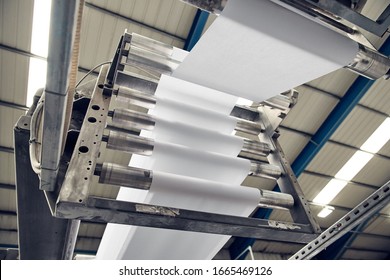 A toilet paper making machine producing toilet and bathroom paper rolls. Paper and tissue manufacturers factory and engineered machinery. Mass produced bathroom products. - Shutterstock ID 1665469126