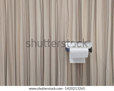 Toilet paper on laminate wall background