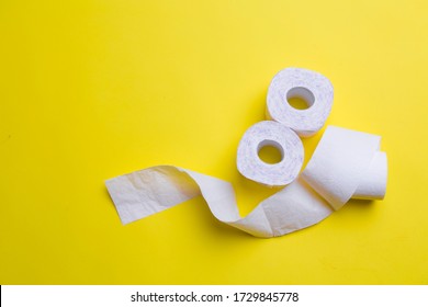 Toilet Paper Rolls On Yellow Background. Everyday Objects In Copy Space. Shortage Of Raw Materials During Period Of Coronavirus. A Popular Product On Market. Delivery Of Goods For House