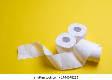 Toilet Paper Rolls On Yellow Background. Everyday Objects In Copy Space. Shortage Of Raw Materials During Period Of Coronavirus. A Popular Product On Market. Delivery Of Goods For House