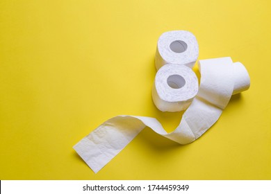 Toilet Paper Rolls On Yellow Background. Everyday Objects In Copy Space. Shortage Of Raw Materials During Period Of Coronavirus. A Popular Product On Market. Delivery Of Goods For House