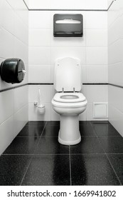 Toilet, toilet room in the style of minimalism. White walls and black floor. Graphics and contrast
