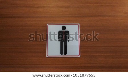 Toilet sign on brown wooden door