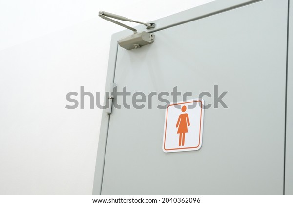 Toilet sign on the toilet door.\
Women WC signs for toilet. Women\'s bathroom on a white\
wall