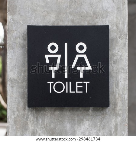 toilet signs on concrete wall