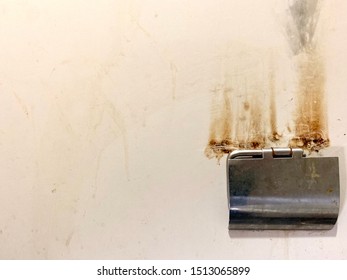 The Toilet Wall Has Burn Marks Caused By Placing A Cigarette.