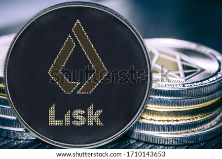 Token cryptocurrency lisk on the background of a stack of coins.