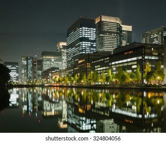 Tokyo Business District With Tall Office Buildings And The Imperial Palace Moat At Night