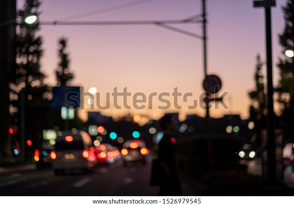 Tokyo city lights and car lights with\
purple and orange sunset sky in twilight\
time