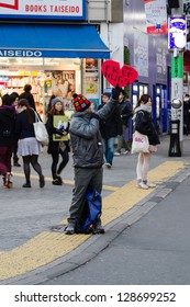 TOKYO, -Â?Â? JANUARY 17: A Young Man With A 'Free Hugs' Sign Embraces A Stranger On January 17, 2013 In Tokyo, Japan.