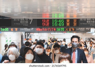 Tokyo, Japan - 04.2022: Crowd Of Commuter Rush To Board The Train To Commute Home During Evening Rush Hour At Shinjuku Station With LED Sign Board Showing Train Schedule And Platform Number