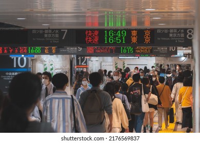 Tokyo, Japan - 04.2022: Crowd Of Commuter Rush To Board The Train To Commute Home During Evening Rush Hour At Shinjuku Station With LED Sign Board Showing Train Schedule And Platform Number