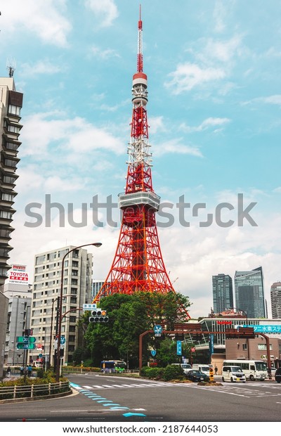 Tokyo, Japan - 04.2022: Tokyo Tower, landmark of\
Tokyo city, with road traffic and cars driving through intersection\
during rush hour