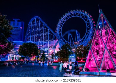 Tokyo, Japan - 05.2022: Abstract Cyberpunk Amusement Park With Neon Lights Illumination. Tokyo Dome City Attractions Amusement Park With Ferris Wheel And Roller Coaster At Night. Futuristic Metaverse