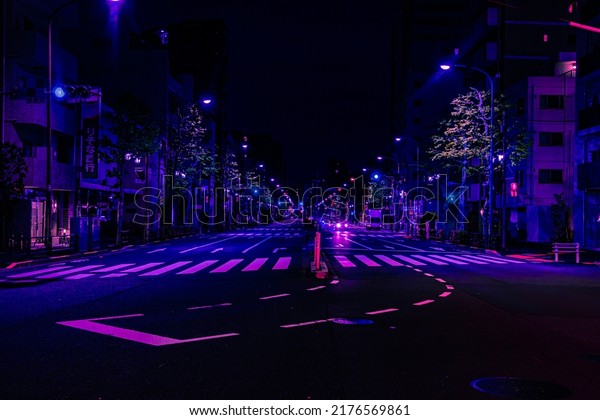 Tokyo, Japan - 05.2022: Abstract neon midnight\
street with no traffic in Shinjuku city. Futuristic metaverse city,\
and cyberpunk.