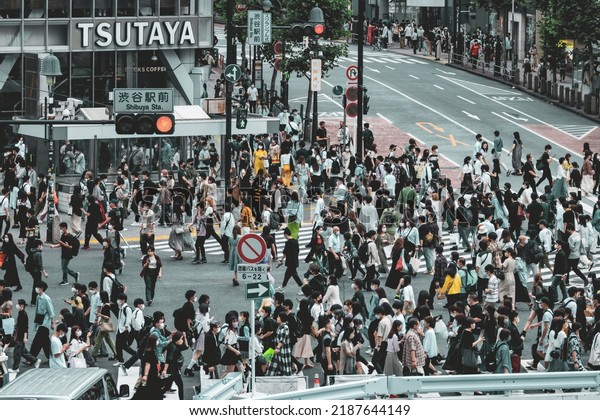 Tokyo, Japan - 06.2022: Crowded\
Shibuya Scramble Crossing at rush hour with people, worker, and\
tourist crossing the crosswalk in hurry to catch commute\
train