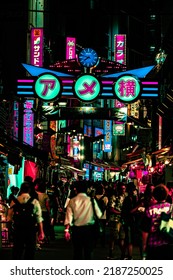 Tokyo, Japan - 08.2022: Neon Ameyoko shopping street in Okachimachi, Ueno at night with illumination from billboard advertisement and izakaya street food restaurant. Futuristic cyberpunk city concept