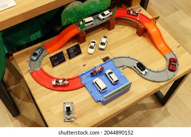 TOKYO, JAPAN - 16 September, 2021: Toy Honda Tomica Cars On A Track In A Honda Showroom.