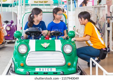 TOKYO, JAPAN - 19 July 2016 - Japanese Tokyo Dome Amusement Park Staff Explains To Two Asian Girls How To Ride On A Furi Furi GP Car At Tokyo Dome City Amusement Park In Tokyo, Japan On July 19, 2016