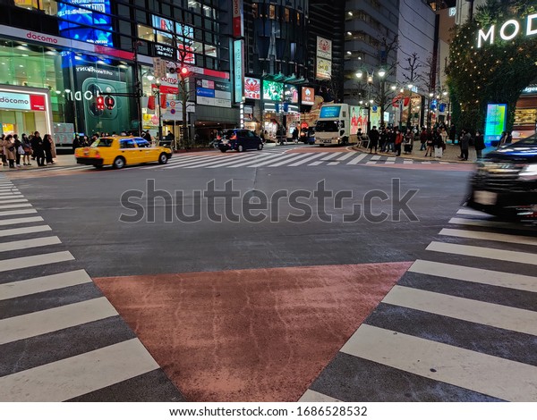 Tokyo, Japan, 2020 \
People crossing famous Shibuya\
Scramble zebra crossing (world\'s busiest cross) as traffic passes\
in evening. It\'s empty than usual as Corona virus (Covid-19)\
spreads through Asia
