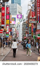 Tokyo, Japan - 23 June 2016: The busy streets of Shinjuku in daytime. Pedestrians walk through the shopping and entertainment area, that is full of shops, cafes and bars with bright signs. 